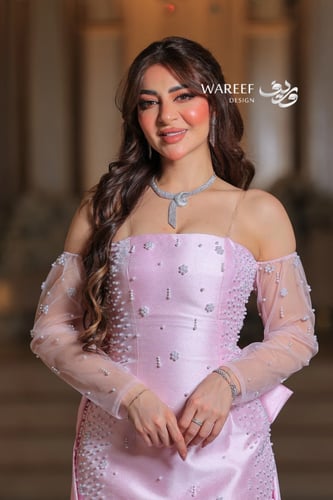 فستان وردي طويل مطرز بلمعة ناعمة مع أكمام شفافة وق...