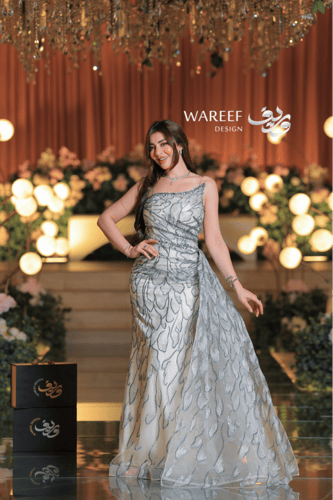 فستان سهرة عاجي فاخر بتطريز زهري لامع وقصّة كتف وا...