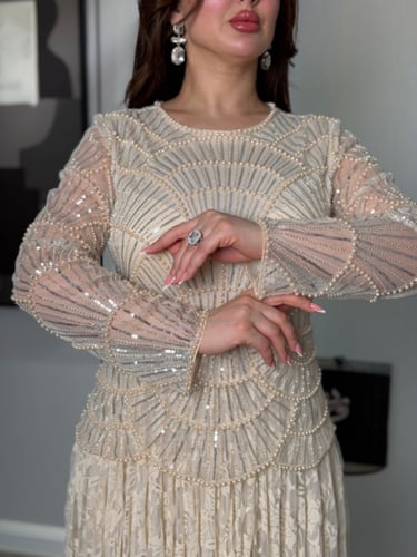 فستان ناعم عاجي بتطريز هندسي وتنورة دانتيل فاخرة