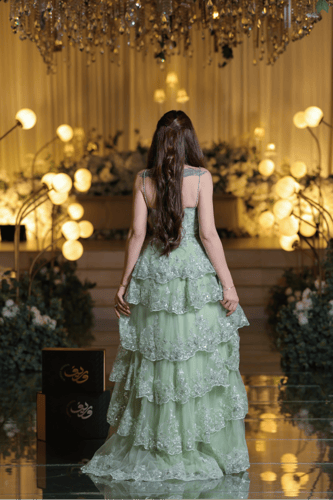 فستان سهرة أخضر فاتح بطبقات تول مطرزة وتصميم حمالا...