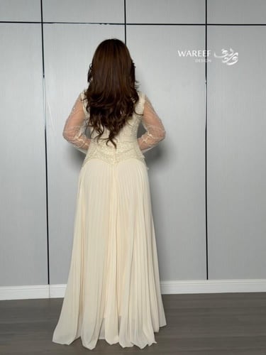 فستان أوف وايت بتطريز لؤلؤي وأكمام شفافة راقية