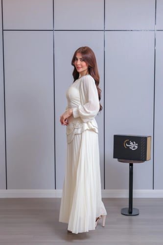 فستان ناعم باللون العاجي بتصميم أنيق وتنورة بليسيه...