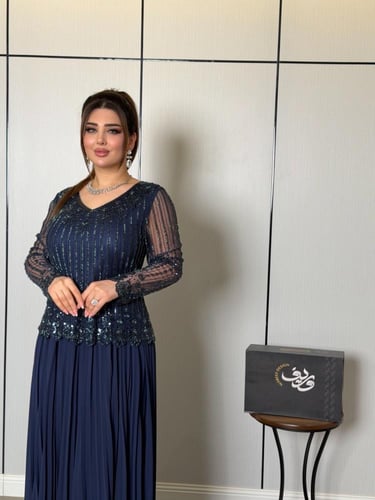 فستان ناعم كحلي بتطريز لامع وأكمام شفافة فاخرة