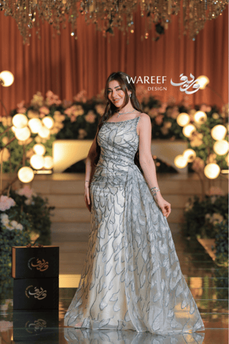 فستان سهرة عاجي فاخر بتطريز زهري لامع وقصّة كتف وا...