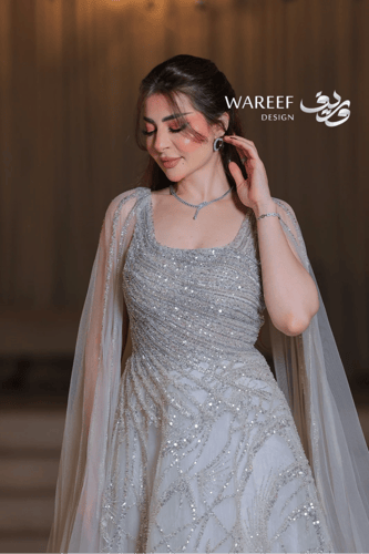 فستان فضي فاخر بتطريز متقاطع ولمعة براقة وأكمام كا...