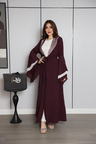 فستان عنّابي بتصميم طبقات وأكمام واسعة بتفاصيل أني...