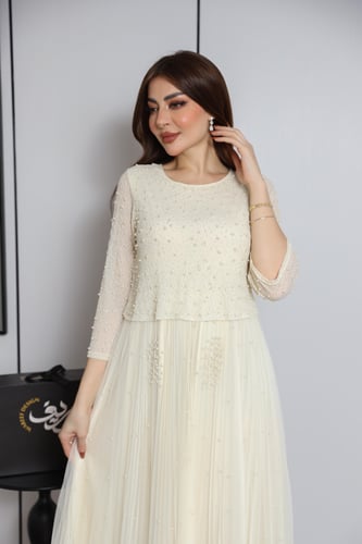 فستان أوف وايت بتطريز ناعم وتنورة بكسرات أنثوية