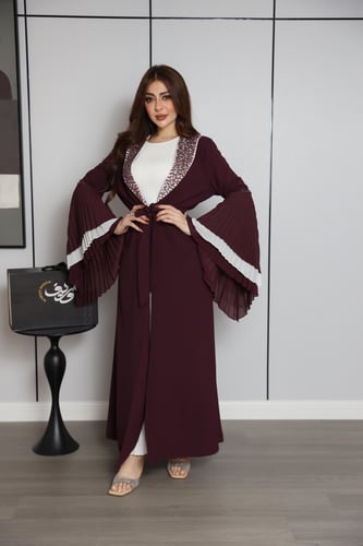 فستان عنّابي بتصميم طبقات وأكمام واسعة بتفاصيل أني...