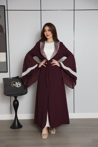 فستان عنّابي بتصميم طبقات وأكمام واسعة بتفاصيل أني...