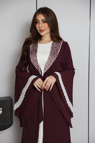 فستان عنّابي بتصميم طبقات وأكمام واسعة بتفاصيل أني...