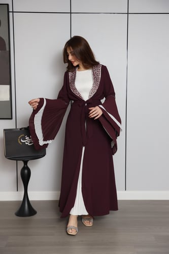 فستان عنّابي بتصميم طبقات وأكمام واسعة بتفاصيل أني...