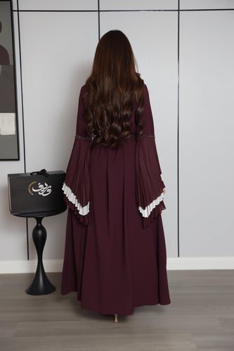 فستان عنّابي بتصميم طبقات وأكمام واسعة بتفاصيل أني...