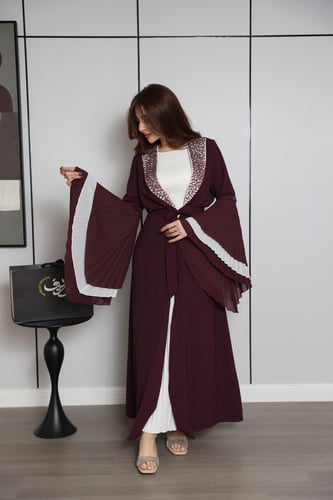 فستان عنّابي بتصميم طبقات وأكمام واسعة بتفاصيل أني...