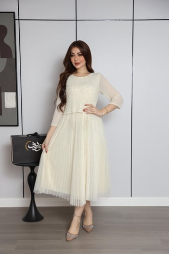 فستان أوف وايت بتطريز ناعم وتنورة بكسرات أنثوية