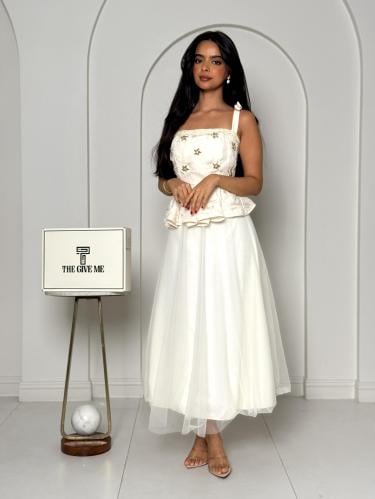 فستان "بيبلوم": توب مطرز بنجوم ذهبية مع تنورة من ا...