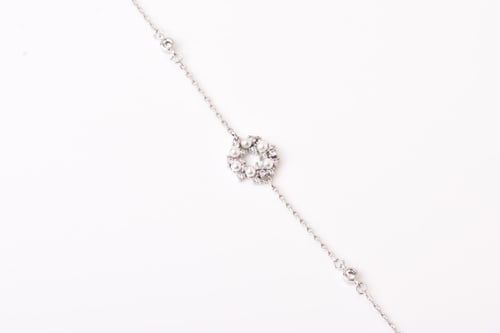 A delicate silver bracelet with a pink design, emb...