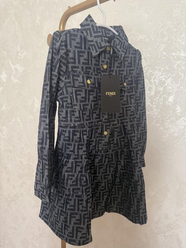 فستان فندي جينز خريفي مزين بأزارير ذهبي عليها علام...