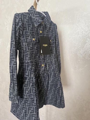 فستان فندي جينز خريفي مزين بأزارير ذهبي عليها علام...