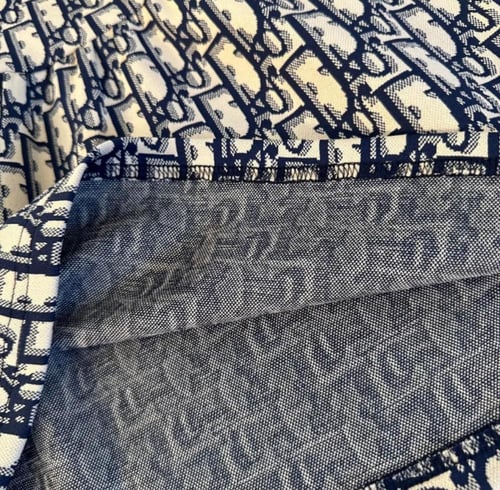 فستان ديور بكتابات مزين بأزارير ذهبي وياقة