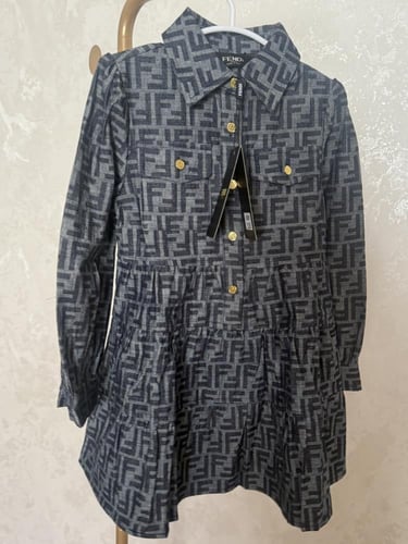 فستان فندي جينز خريفي مزين بأزارير ذهبي عليها علام...