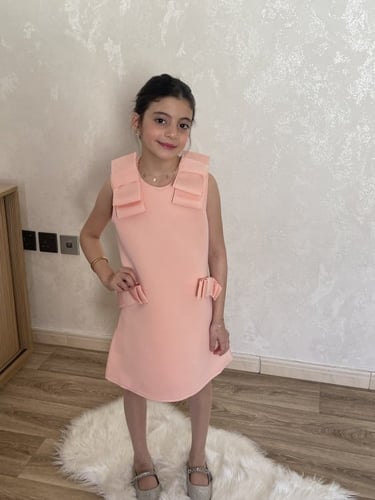 فستان باللون المشمشي للمناسبات مزين بفيونكات