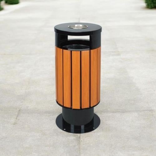 سلة مهملات خارجية اسطوانية الشكل اسود على خشبي مع...