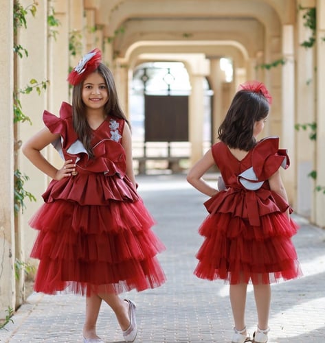 فستان أطفال بطبقات من التل والتفته باللون العنابي...