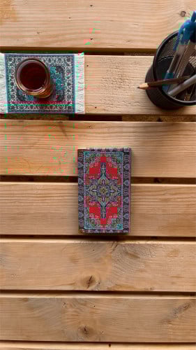 مُفكرة صغيرة بغلاف السجاد مزخرف احمر.