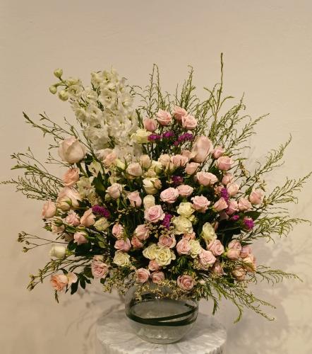 Oval transparent vase with white dolphin flowers a...