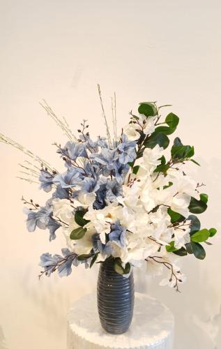 Blue pottery vase with artificial cream and blue f...