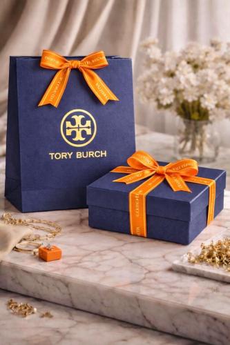 Tory Burch accessories include a large bag, a box,...