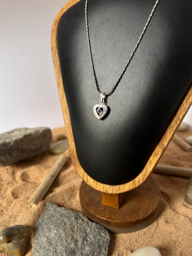 A silver necklace in the shape of a heart