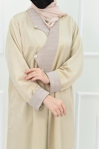 عباية شتوية بلون كريمي مع تفاصيل جلد
