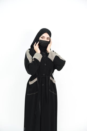 عباية عملية مع ربطة وجيوب بتفاصيل بيج