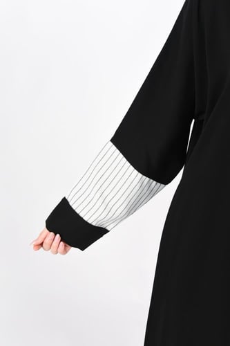 عباية سوداء بتفاصيل بيضاء مقلمة بالأسود