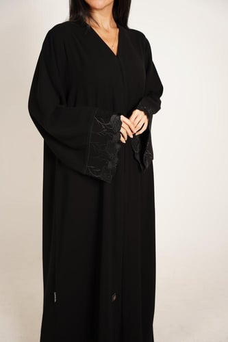 عباية كريب سوداء بأكمام مطرزة وحواف مموجة
