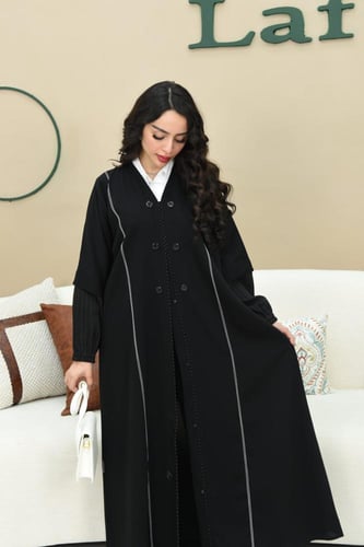 عباية كريب يزينها أزرار وخطوط بيضاء أنيقة