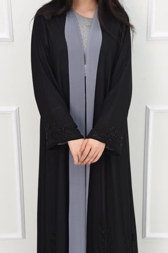 عباية سوداء مبطنة بالرصاصي مع تفاصيل مطرزة على الأ...