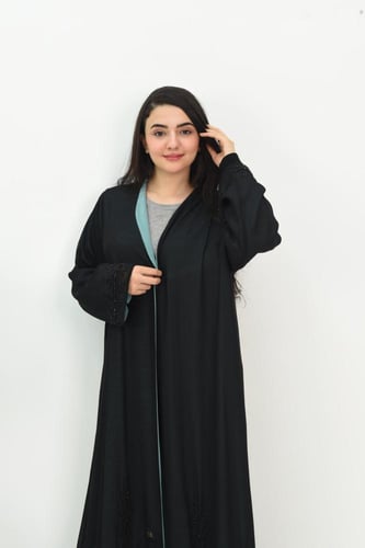 عباية سوداء مبطنة بقماش بلون تركواز مع تفاصيل مطرز...