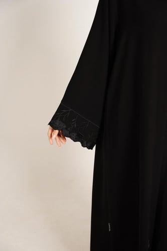 عباية كريب سوداء بأكمام مطرزة وحواف مموجة