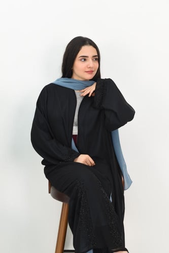 عباية سوداء مبطنة بقماش سماوي مع تفاصيل مطرزة على...