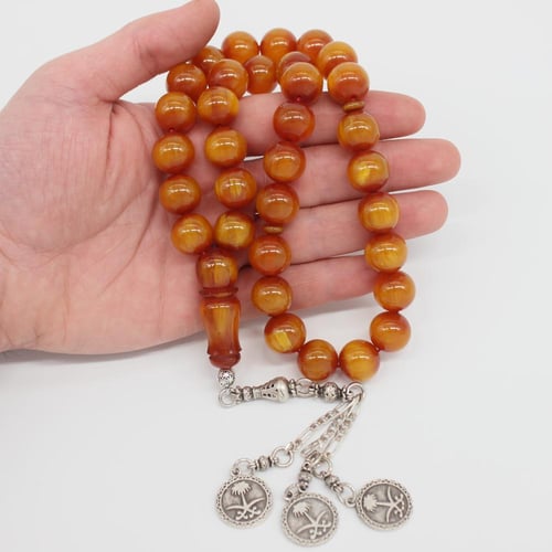 سبحة مسكي عسلي مموج معتقة بشرابة تحمل شعار المملكة