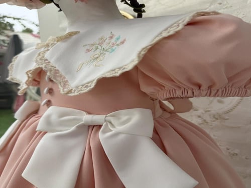 فستان خربزي بفيونكات بيضاء