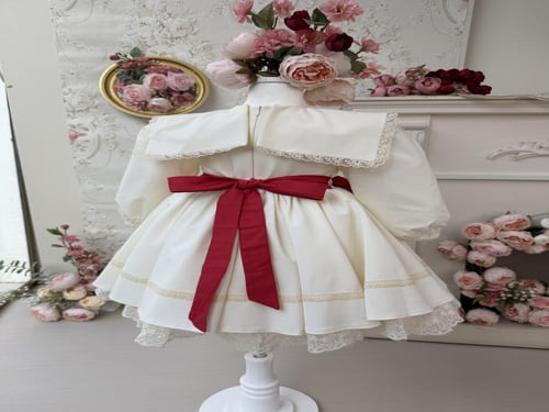 فستان كريمي بفيونكات حمراء