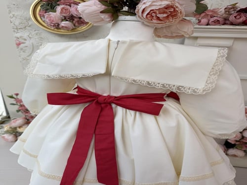 فستان كريمي بفيونكات حمراء