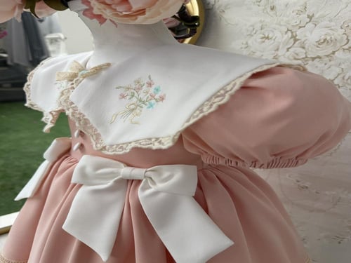 فستان خربزي بفيونكات بيضاء