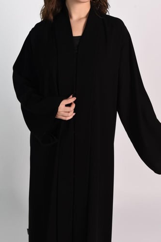 عباية سوداء بتطريز فضي في الجزء السفلي.