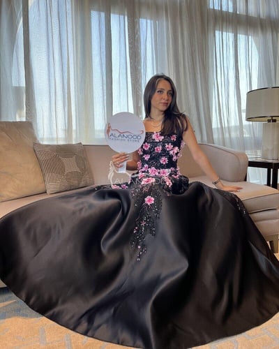 فستان سهرة أسود مزين بزهور وردية بتصميم راقٍ