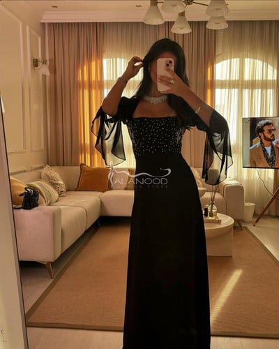 فستان أسود ناعم للأعياد بتصميم متقن