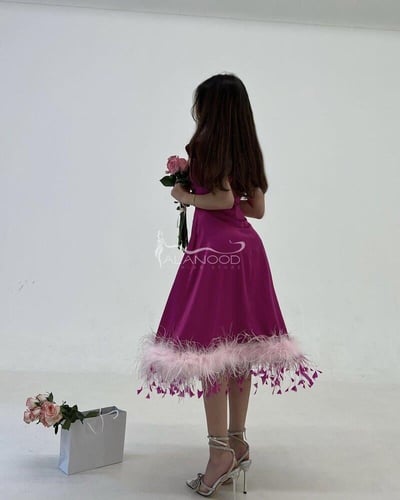 فستان العيد 2025 بلون فوشي ميدي بتصميم عصري مع ريش...